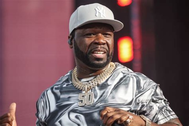 50 Cent in silver hat standing close with Vivica A. Fox for event