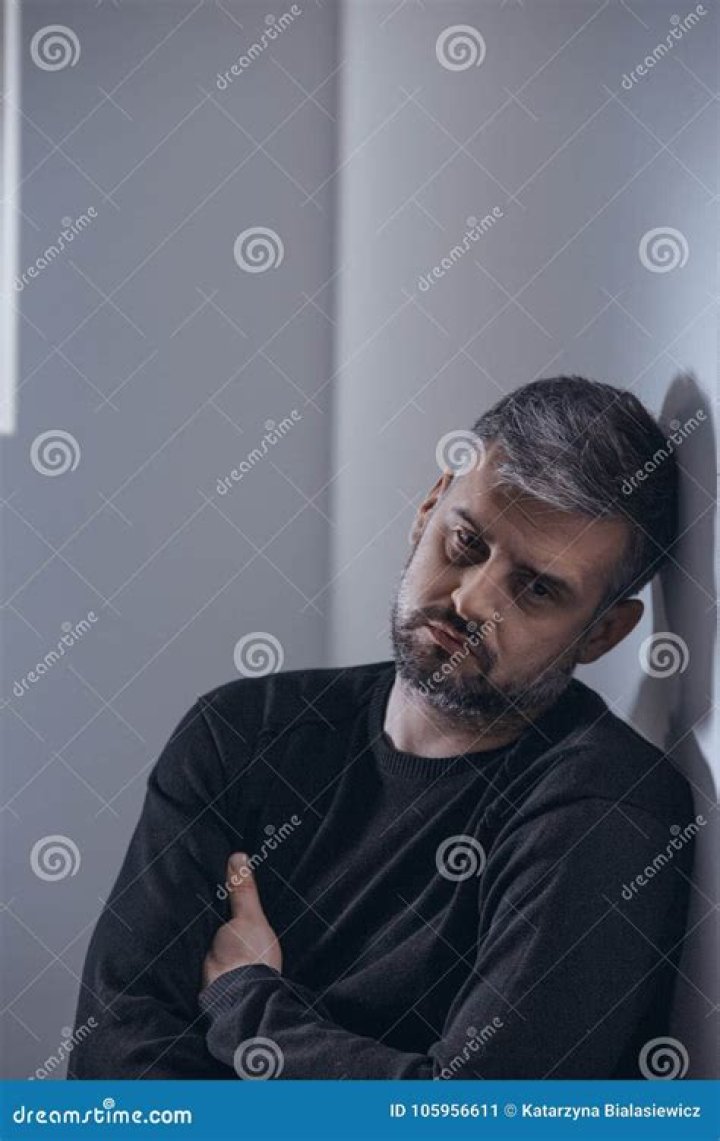A sad man is leaning on a wooden table A sad man is leaning on a wooden table