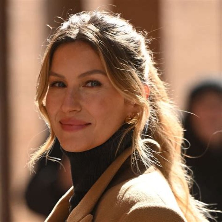 Gisele Bündchen smiling while looking at Leonardo DiCaprio at the Academy Awards.