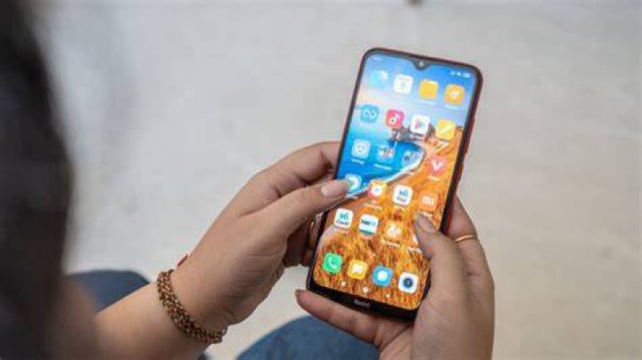 Redmi 8 in hand showing redmi logo Redmi 8 in hand showing redmi logo
