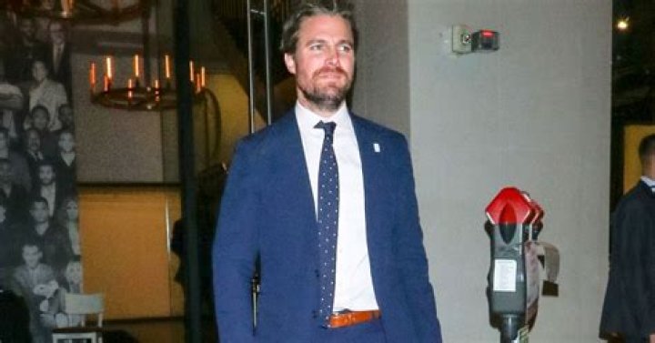 Stephen Amell looking at something as he walks outside