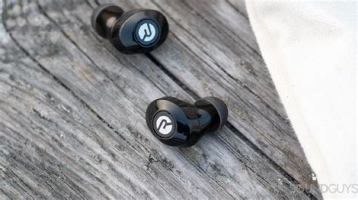 Raycon E25 earbuds 5 of 8 The Raycon E25 earbuds on a wood surface.